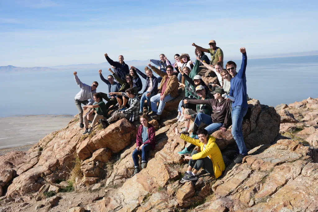 Group of citizens raising fists in the air, atop a rock overlooking Great Salt Lake.
